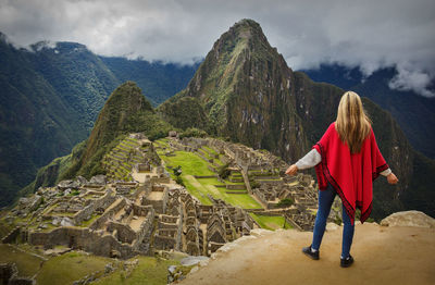 Rear view of woman standing against mountains