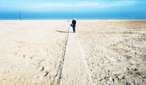 Rear view of man walking on beach