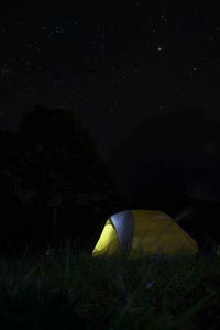 Illuminated tent against star field at night