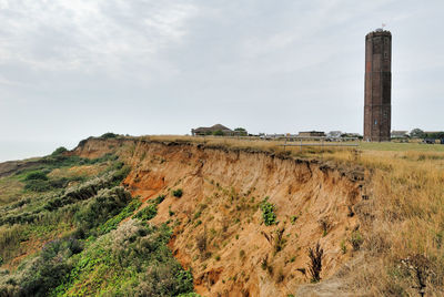 Scenic view of land and tower against sky