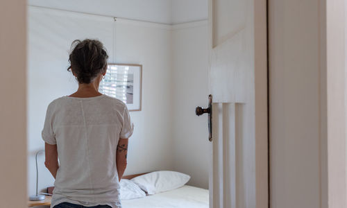 Rear view of man standing at home