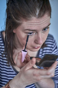 Close-up of woman applying mascara