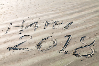 Text and number on sand at beach