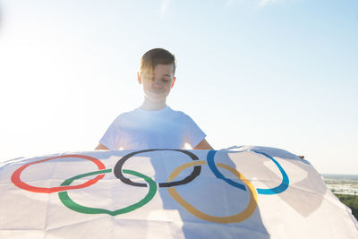 Portrait of boy standing against blue sky