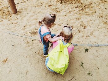 High angle view of mother with daughter at sandy beach