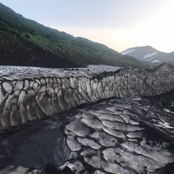Scenic view of river by mountains against sky