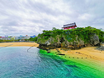 View of building by sea against cloudy sky