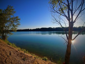 Scenic view of lake against clear blue sky