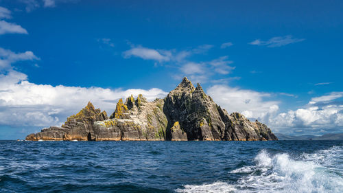 Rock formation in sea against sky