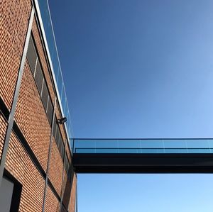 Low angle view of modern building against blue sky