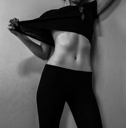 Midsection of woman standing against wall