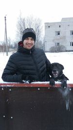 Portrait of happy boy with dog in winter