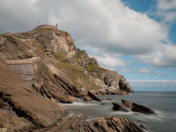 Scenic view of rocky beach against sky