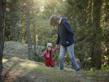 Rear view of woman walking in forest