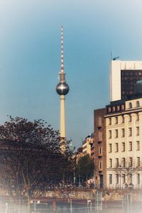 Communications tower and buildings against sky