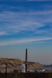 Wooden posts on field against sky