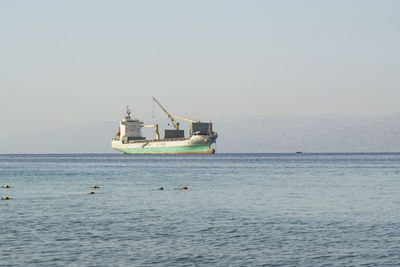 Ship sailing in sea against sky