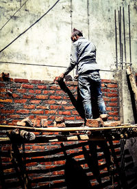 Rear view of man walking on staircase