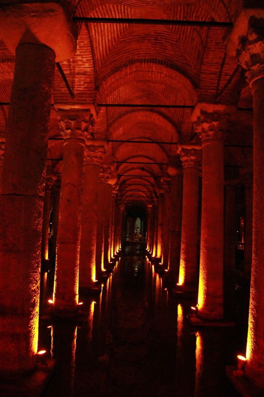 architecture, indoors, built structure, the way forward, arch, corridor, diminishing perspective, in a row, architectural column, colonnade, vanishing point, history, illuminated, ceiling, narrow, empty, column, lighting equipment, no people, religion