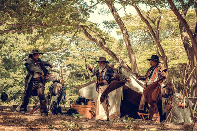 People by tent in forest