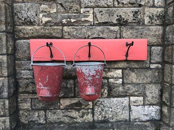 Old buckets hanging against stone wall