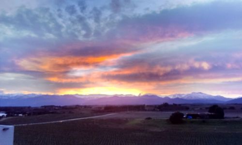 Scenic view of mountains against cloudy sky at sunset