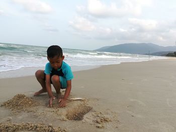 Boy playing on sand at beach