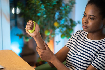 Female hand exercising with silicone grip ring for hand flexibility and improve blood circulation.