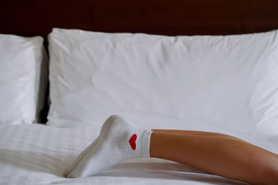 Woman laying in bed wearing white socks with hearts