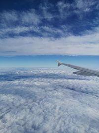 Airplane flying over cloudscape against sky