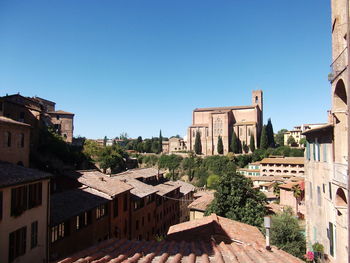 Buildings in city against clear blue sky