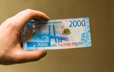 Close-up of man holding money against brown background