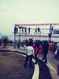 Rear view of people walking on bridge