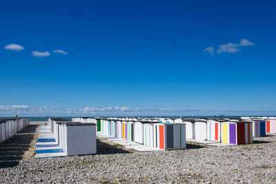 Multi colored chairs on beach against blue sky