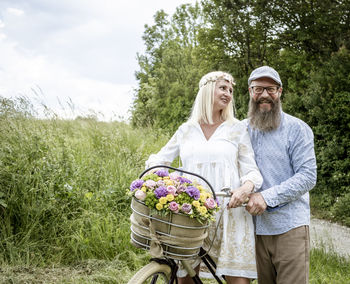 Full length of couple with bicycle against plants