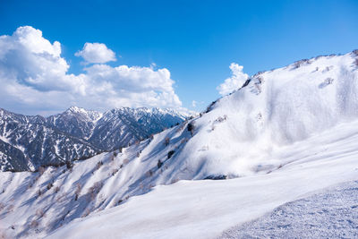 Scenic view of snow covered mountains against sky