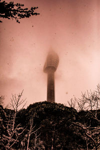 Low angle view of water tower against cloudy sky