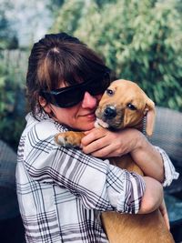 Smiling mature woman embracing dog