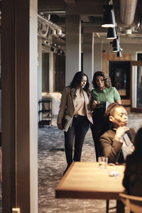 Mature female business colleagues planning strategy while walking in office