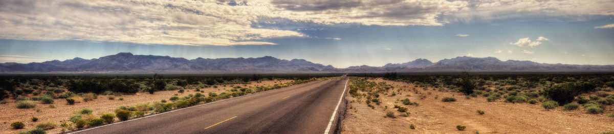 Empty road along countryside landscape