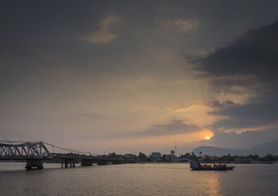 Bridge over river against sky during sunset