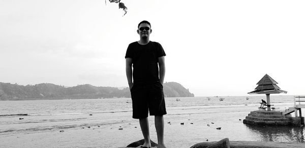 Man standing on beach against sky