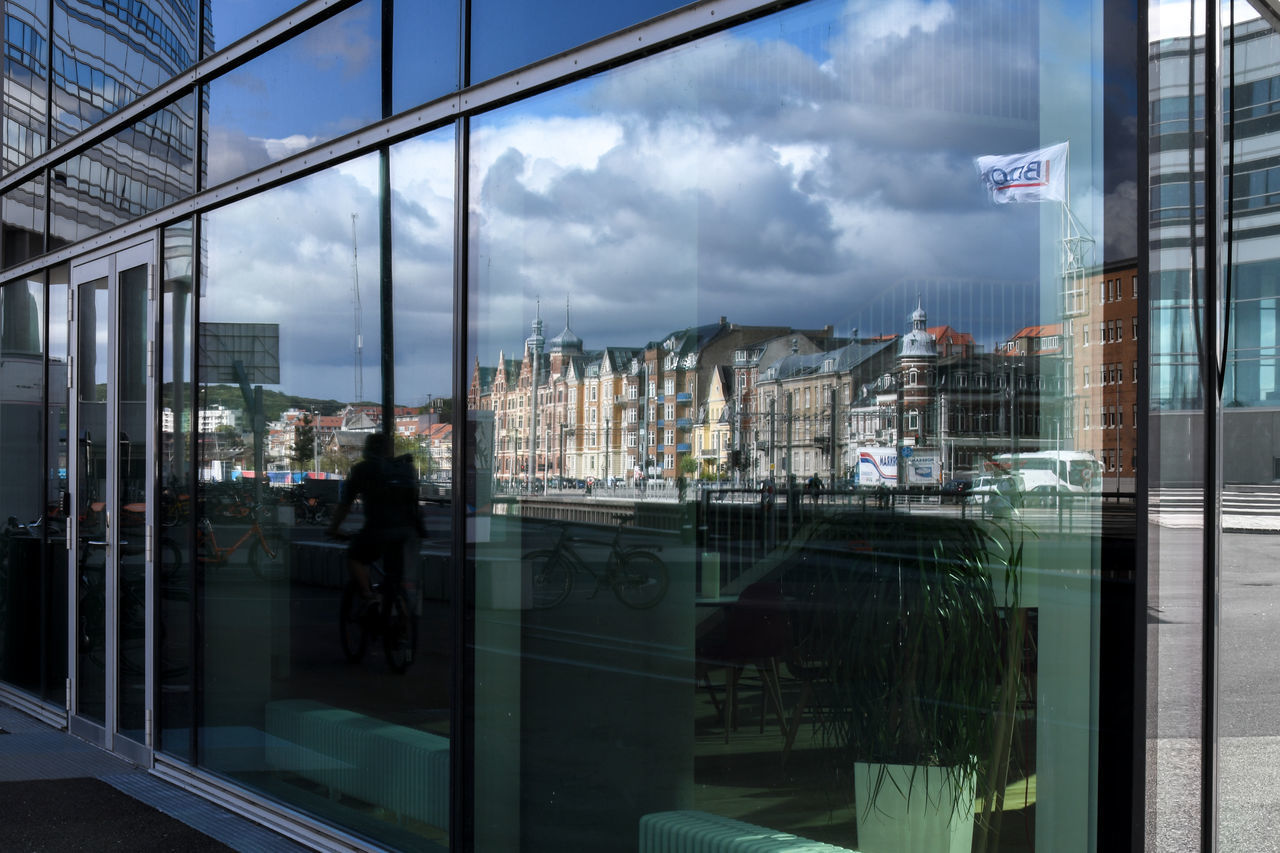 REFLECTION OF BUILDINGS ON GLASS WINDOW