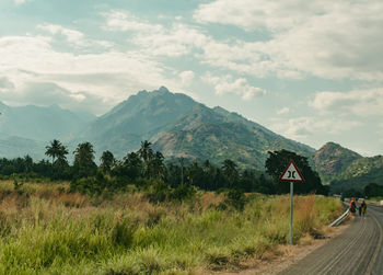 Road amidst field against sky