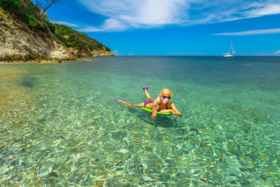 Woman swimming in sea against sky