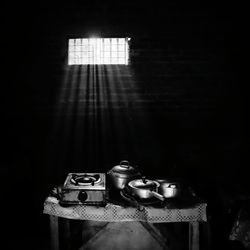 Sunbeams over old stove with utensils in kitchen