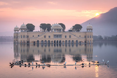 View of birds in lake at sunset