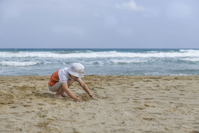 Full length of child on beach against sky