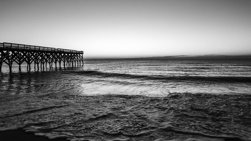 Pier over sea against clear sky