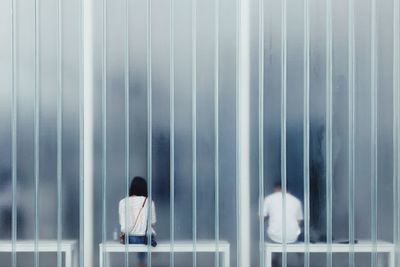 Rear view of people seen through window sitting on seats